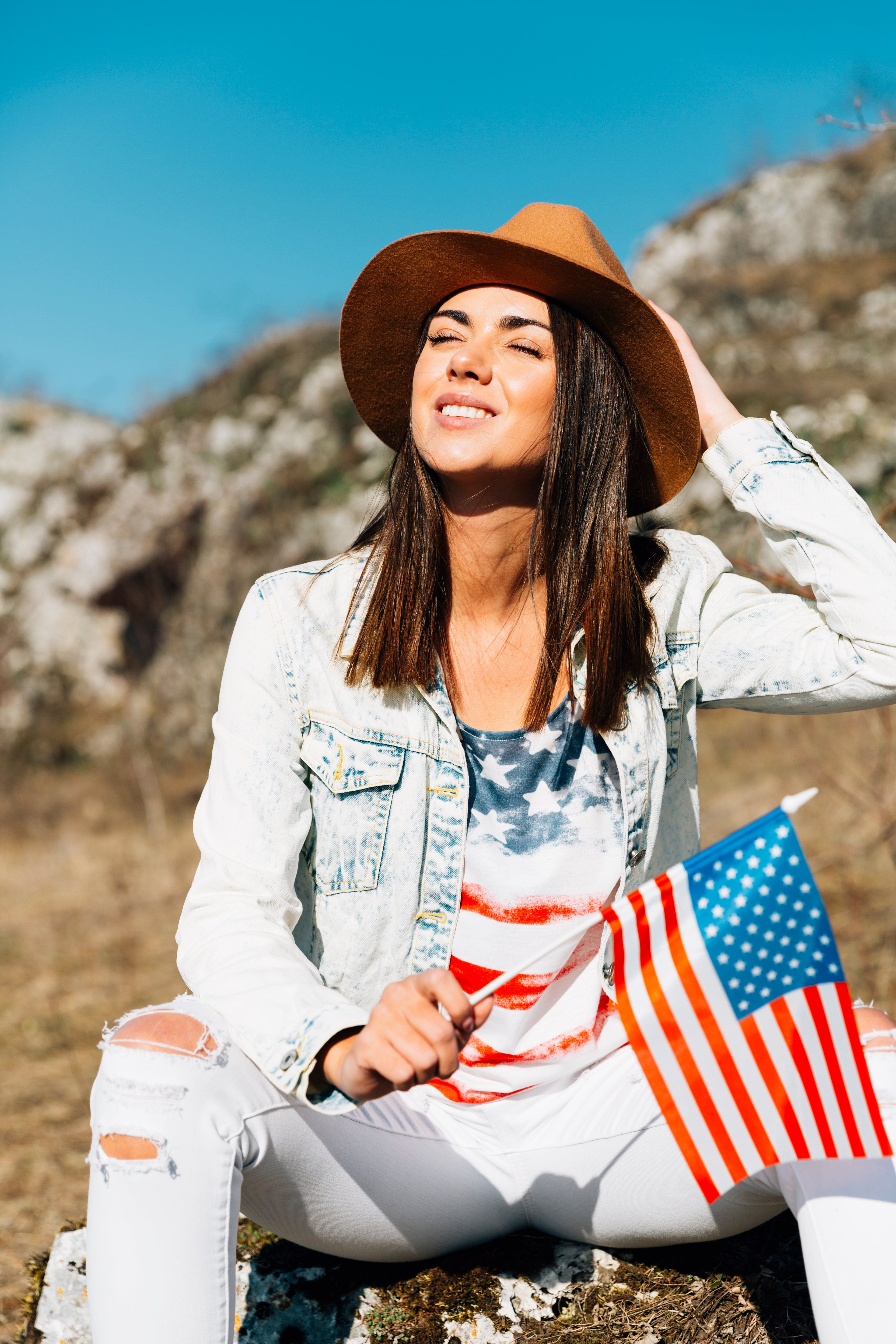 files/smiling-woman-sitting-stone-with-flag.jpg